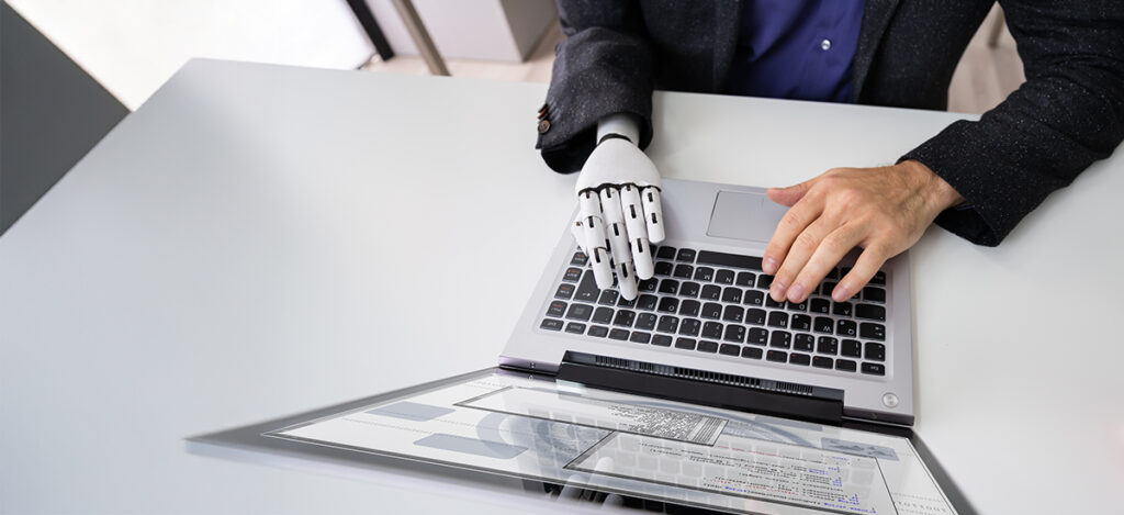 Man With Robotic Hand Working On Laptop